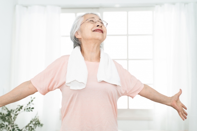 両手を広げる高齢女性